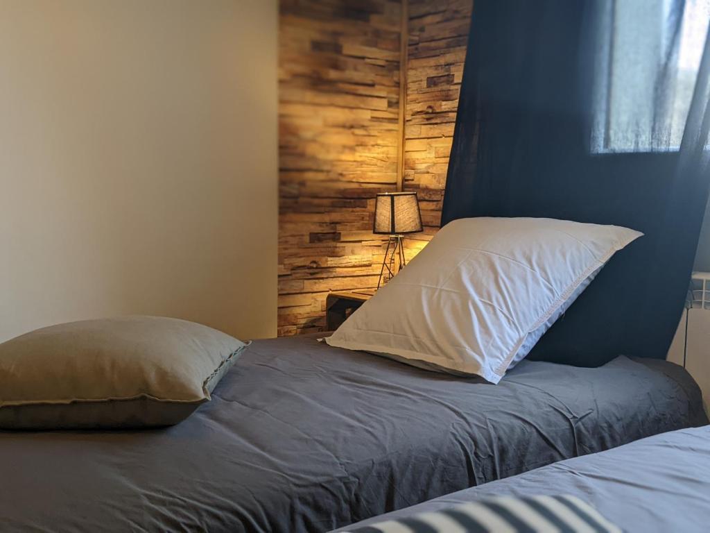 - une chambre avec un lit et un mur en bois dans l'établissement Chez Lou appartement proche du lac moderne, à Annecy