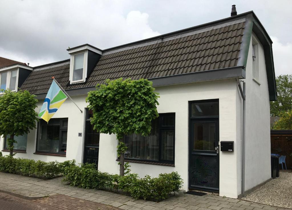 een wit gebouw met een vlag ervoor bij Op Nijverdal in Nijverdal