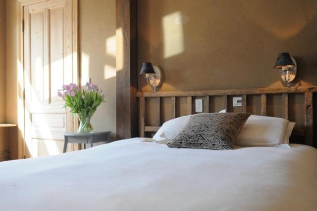 - une chambre avec un lit blanc et un vase de fleurs dans l'établissement B&B 1669, à Bruges