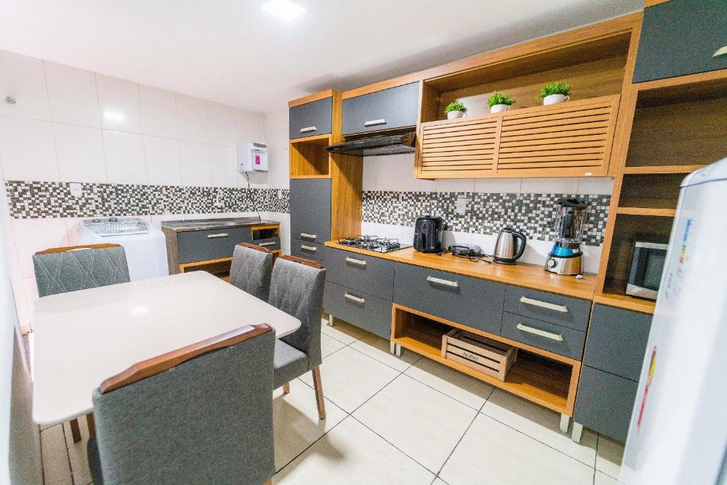 eine Küche mit Tisch und Stühlen in einem Zimmer in der Unterkunft Apartamentos Com Suite ,Wi-Fi 500MB , Estacionamento, Elevador, Cozinha Completa , Jr Catito in Brasilia