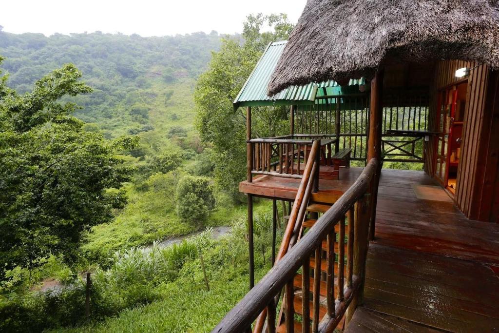 a balcony of a house with a view of the forest at Treehouse River Lodge in Elangeni