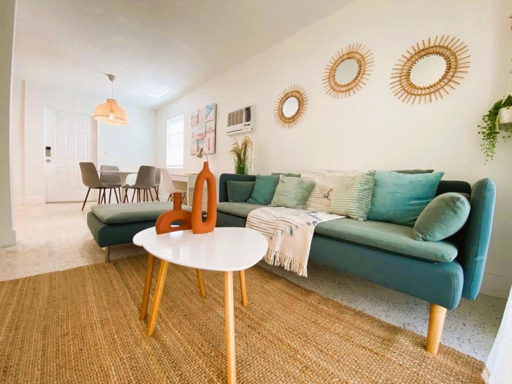 een woonkamer met een blauwe bank en een tafel bij Cozy Apartment Near Brickell in Miami