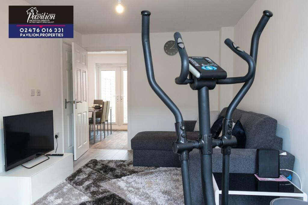 a living room with a exercise bike in front of a couch at Lovely Brand New 2 Bed House with Driveway Parking in Longford