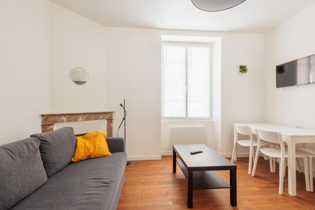- un salon avec un canapé gris et une table dans l'établissement LE CHEZY, à Rennes