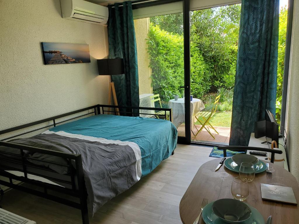 Appartement avec jardin privatif في ألبي: غرفة نوم بسرير وطاولة ونافذة