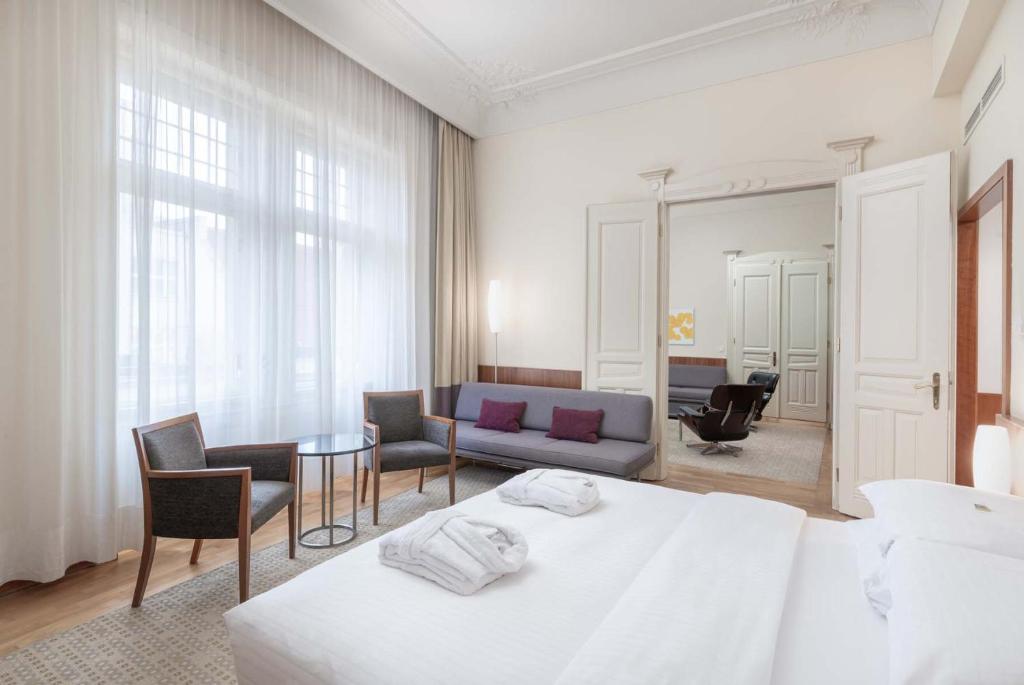 een slaapkamer met een bed, een bank en een tafel bij K+K Hotel Central in Praag