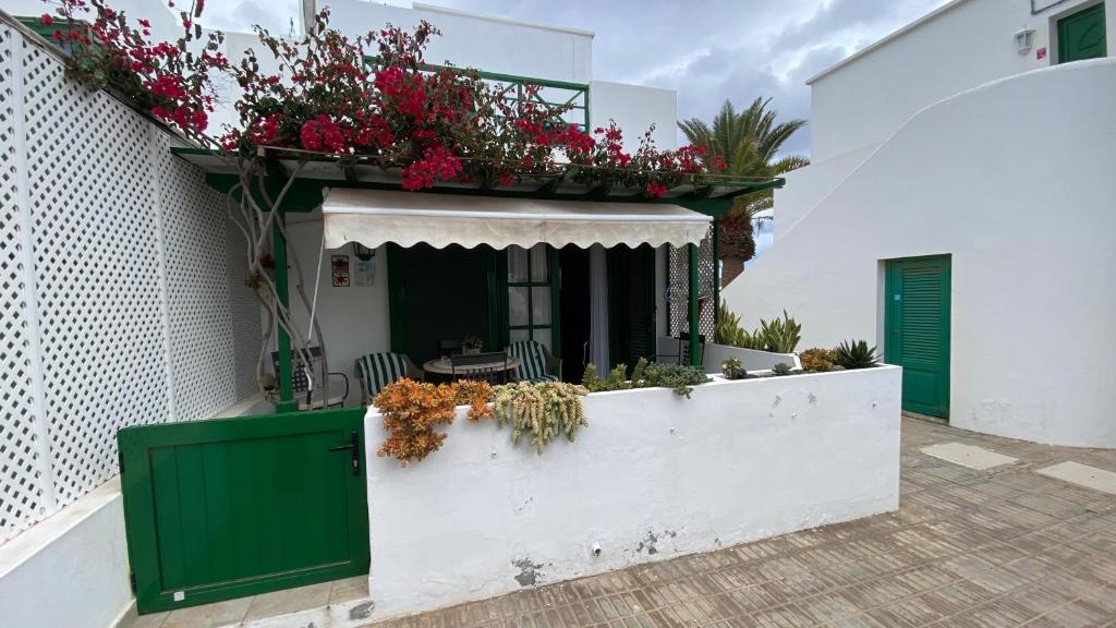un edificio bianco con balcone fiorito di CASA OASI a Playa Blanca