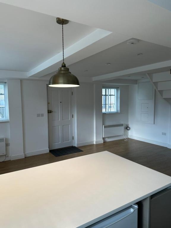 an empty room with a white table and a ceiling at The Pump House in St. Ives