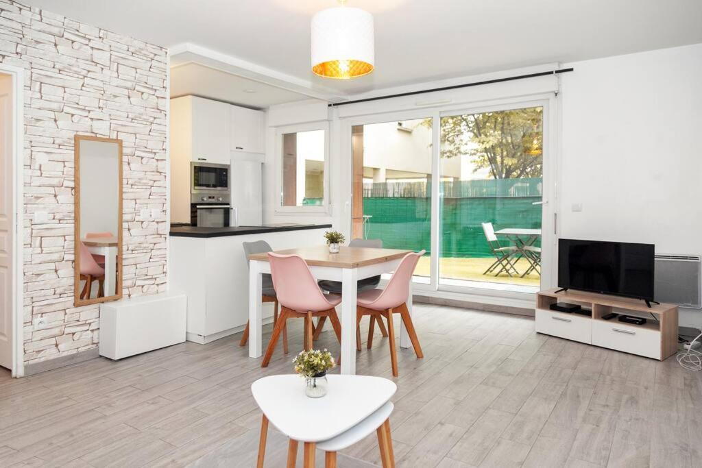 a kitchen and living room with a table and chairs at Appartement cosy à 10 min de Disneyland Paris ! in Montévrain