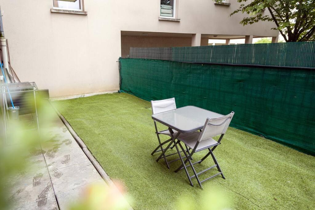 a table and two chairs sitting on a lawn at Appartement cosy à 10 min de Disneyland Paris ! in Montévrain