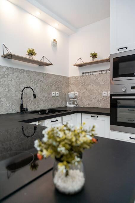a kitchen with a vase of flowers on a counter at Appartement cosy à 10 min de Disneyland Paris ! in Montévrain