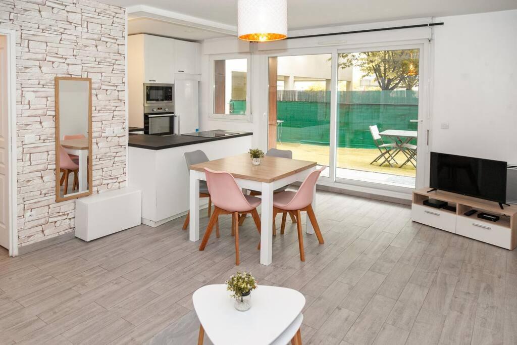 a kitchen and living room with a table and chairs at Appartement cosy à 10 min de Disneyland Paris ! in Montévrain
