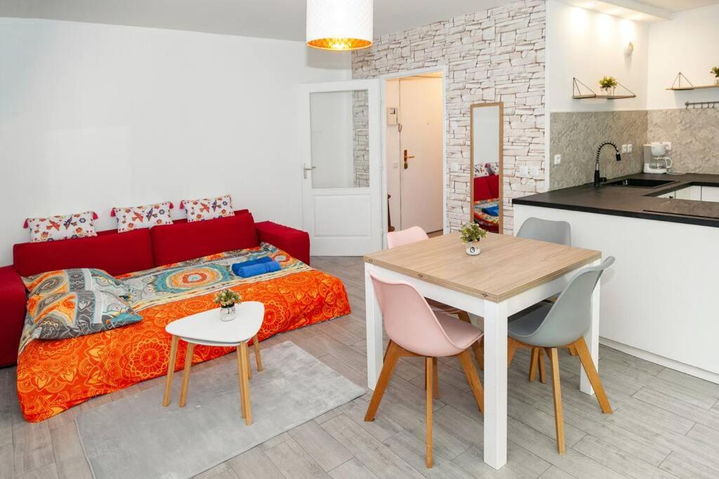 a bedroom with a red bed and a table and chairs at Appartement cosy à 10 min de Disneyland Paris ! in Montévrain
