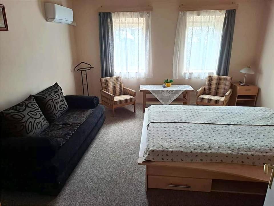 una camera con letto, divano e tavolo di Dunakanyar Vendégház a Szob
