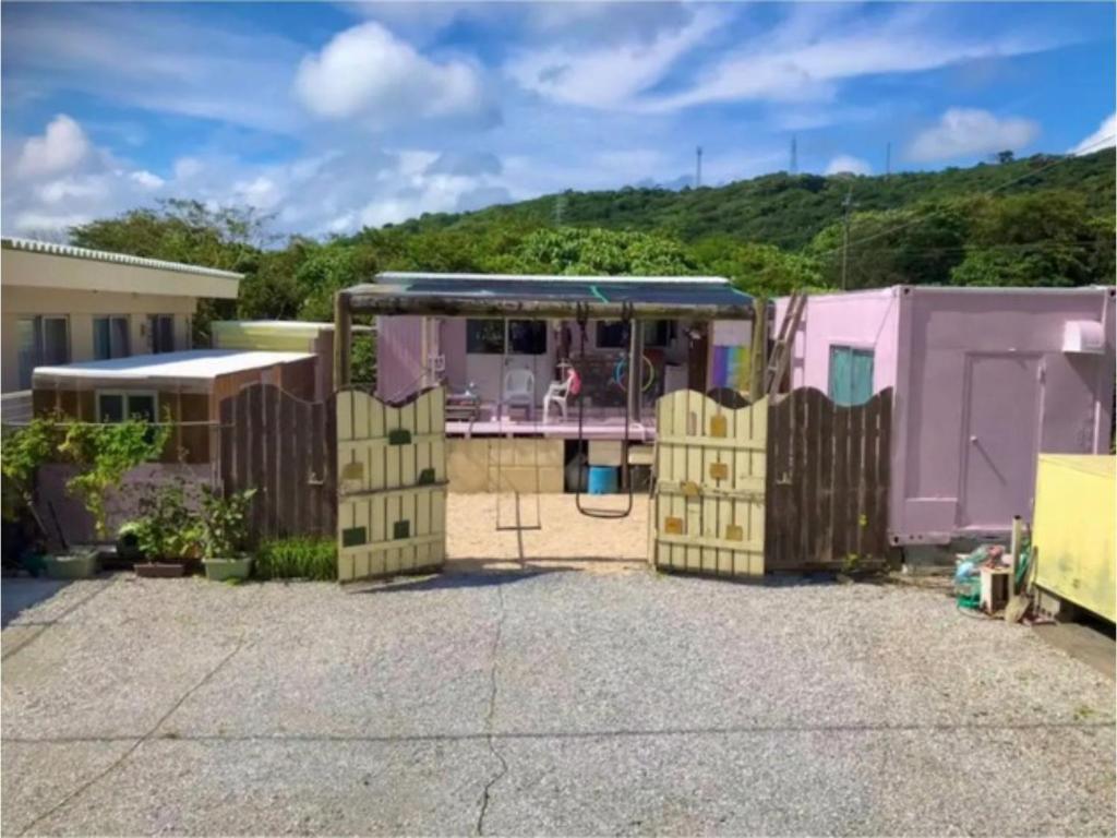 une maison violette avec un portail et une clôture dans l'établissement GUEST HOUSE SUMIRE - Vacation STAY 34298v, à Nago