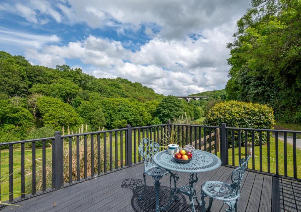 a table with a bowl of fruit on a wooden deck at Clippity Clop in Ponsanooth