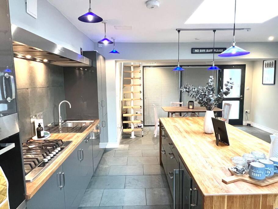 uma cozinha com um balcão de madeira e luzes azuis em The Old Bakery em Cheltenham