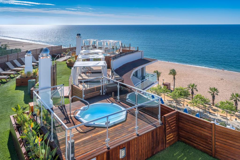 a deck of a yacht with a hot tub and a beach at GHT Maritim in Calella