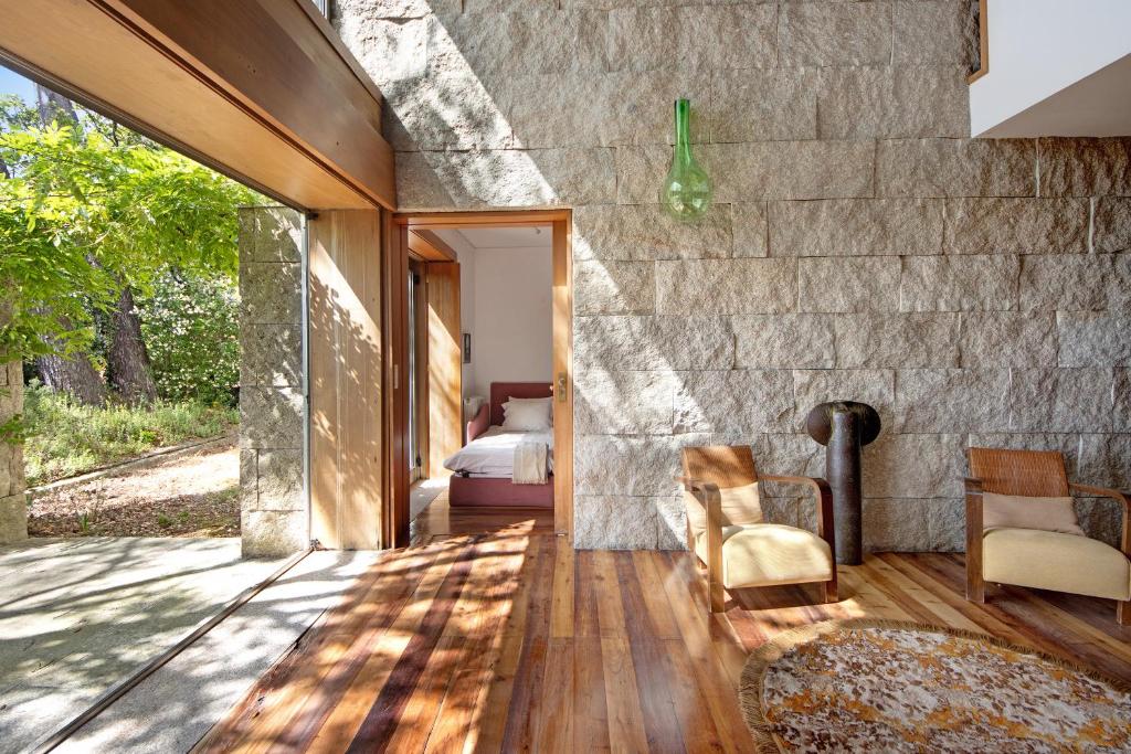 a room with a stone wall and a bedroom at Villa do Bosque in Guilhabreu