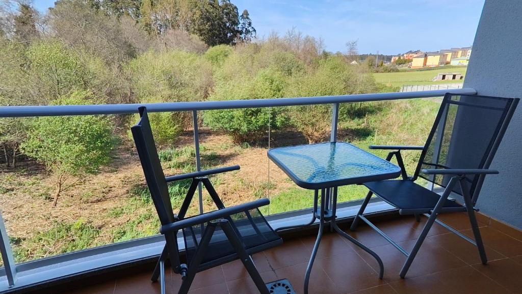 dwa krzesła i stół na balkonie z widokiem w obiekcie O meo refuxio w mieście Barreiros