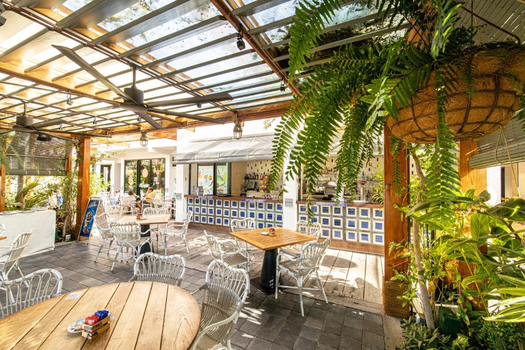 a restaurant with tables and chairs and plants at Parque Santiago III Official in Playa de las Americas