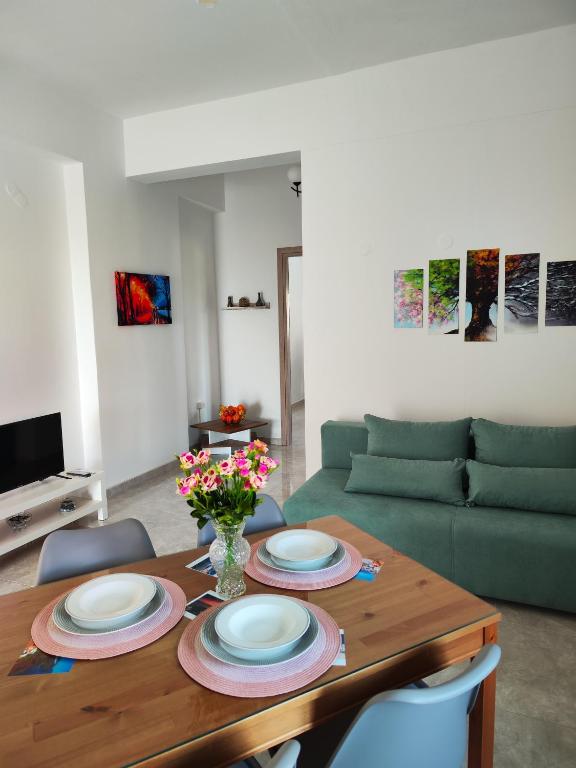 a dining room table with plates and flowers on it at Oasis Apartments in Perissa