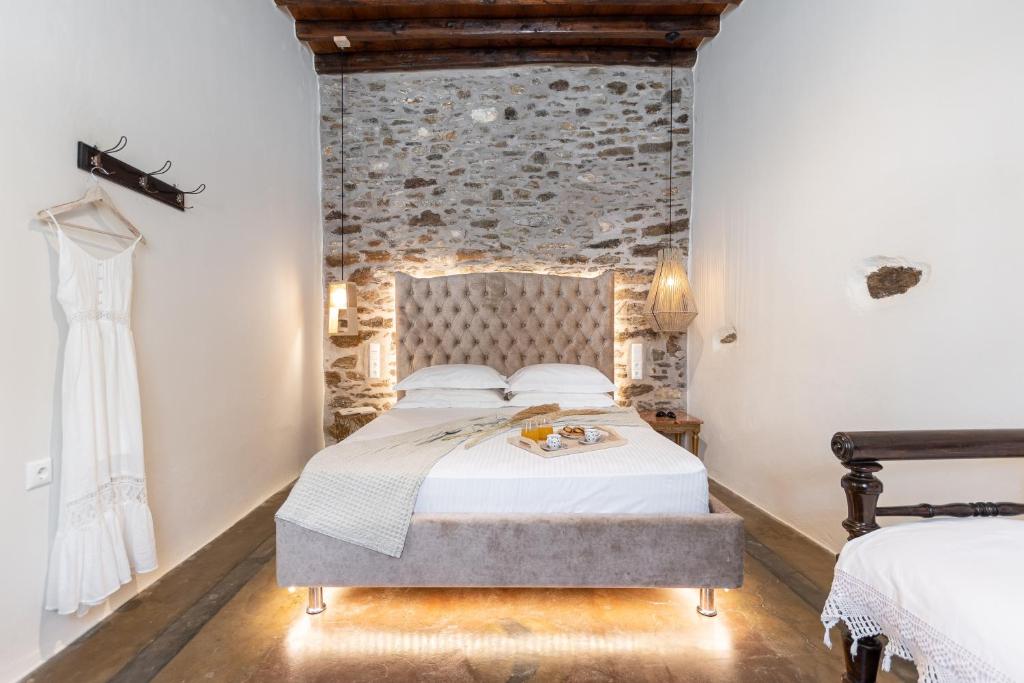 a bedroom with a bed and a brick wall at The Locals in Káto Potamiá