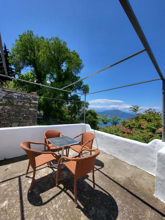 a patio with two chairs and a table on a roof at Παραδοσιακό σπίτι με θέα in Tríkeri
