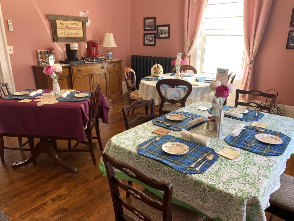 a dining room with two tables with plates of food at Seabank House Bed and Breakfast Ahoy in Pictou
