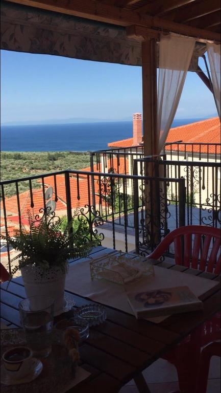 a table on a balcony with a view of the ocean at Villa sunset Antigoni in Kallirákhi