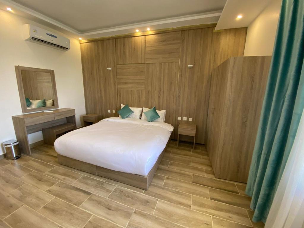 um quarto com uma cama branca e uma parede de madeira em Castle beach hotel em Aqaba