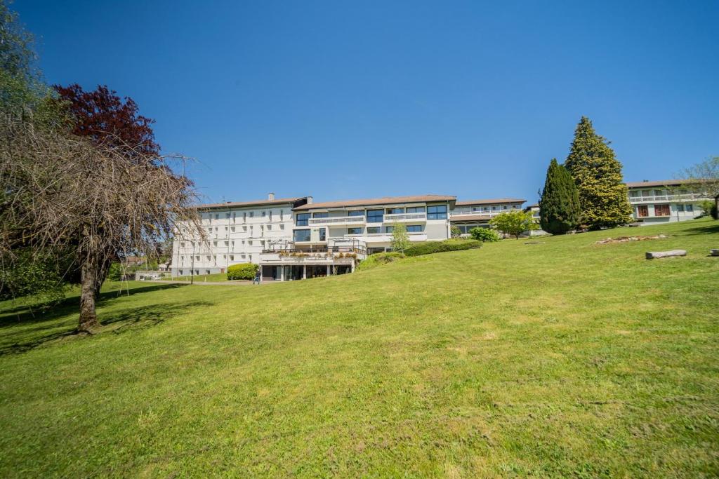 un grand champ herbeux devant un bâtiment dans l'établissement Centre Jean XXIII, à Annecy