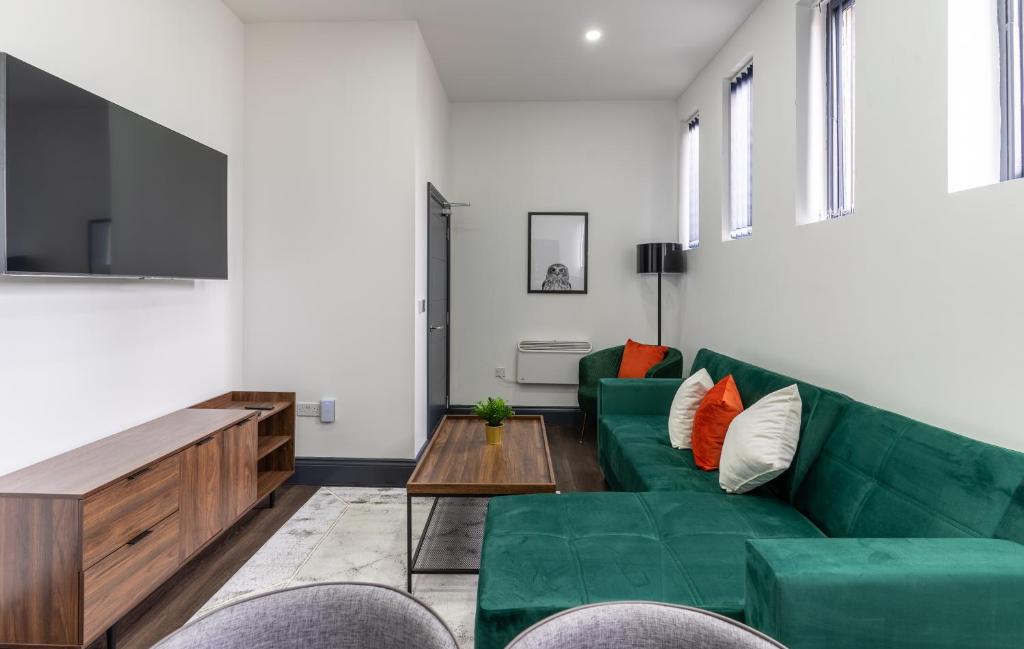 a living room with a green couch and a table at Water Street by Ustay Aparthotels in Liverpool