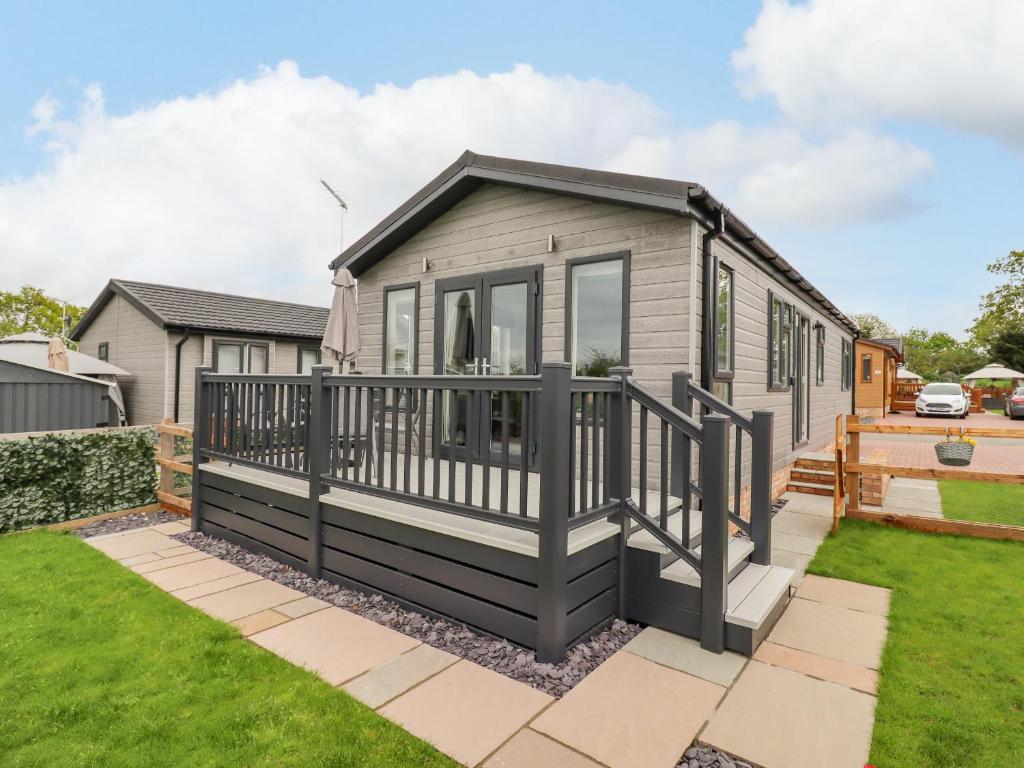 a tiny house with a deck in a yard at 36 Bucklesham Park in Ipswich