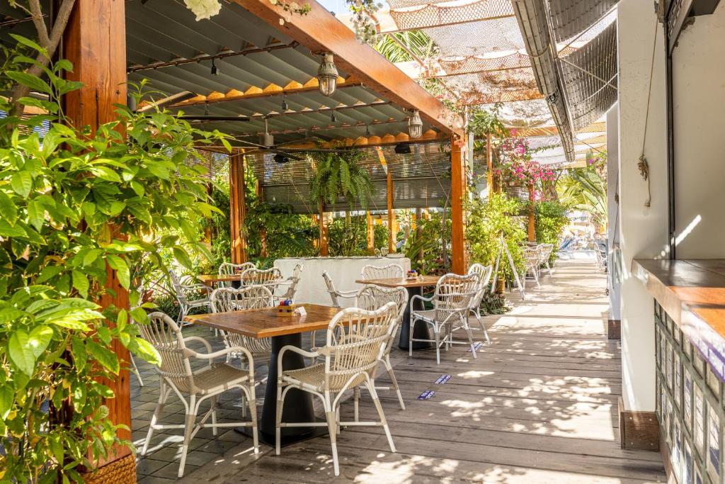 an outdoor patio with tables and chairs and plants at Parque Santiago III Official in Playa de las Americas