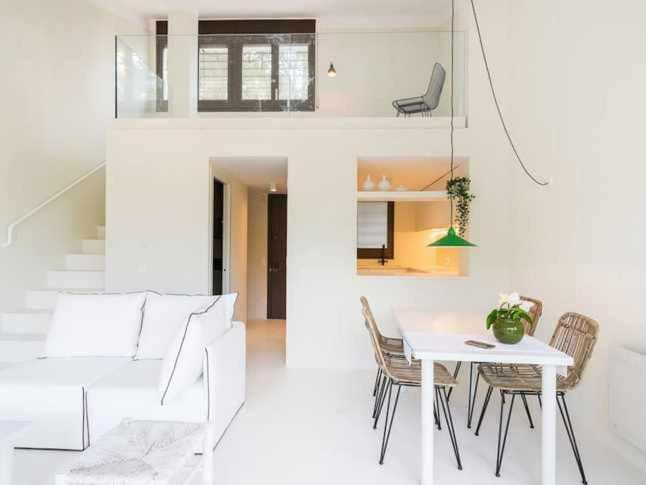 ein weißes Wohnzimmer mit einem Tisch und Stühlen in der Unterkunft Brisa Blanca Sa Riera Begur in Begur