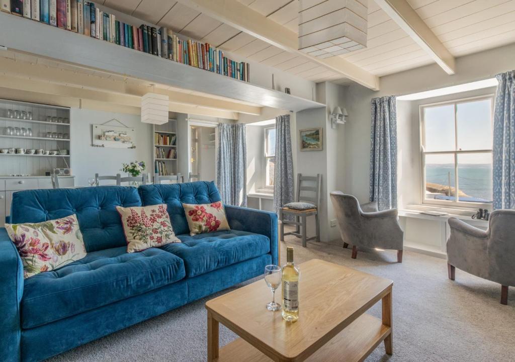 a living room with a blue couch and a table at The Kellan in Mousehole