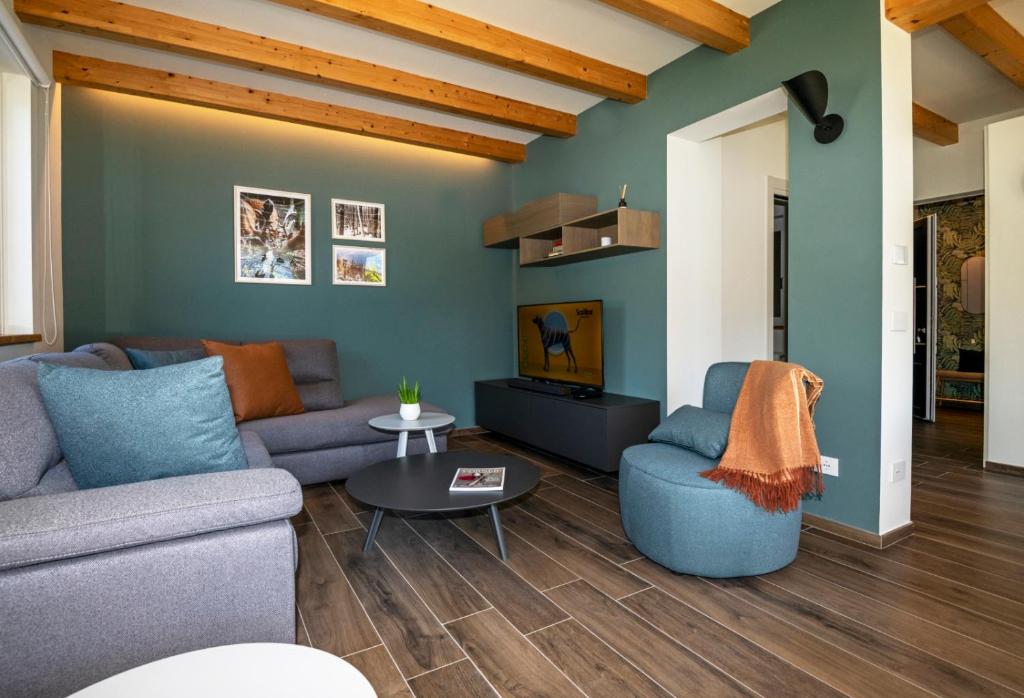 uma sala de estar com um sofá e uma televisão em La Maison du Renard, villa con giardino e vista sulle montagne em Aosta