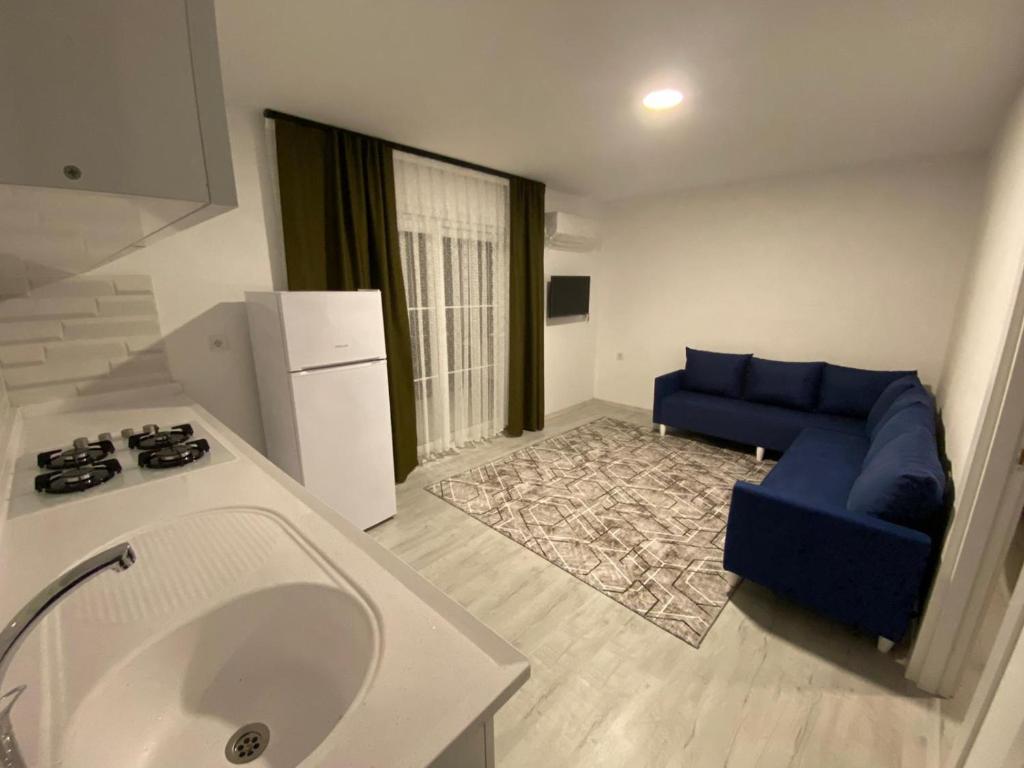 a living room with a blue couch and a blue chair at CanBey Apartları in Adrasan
