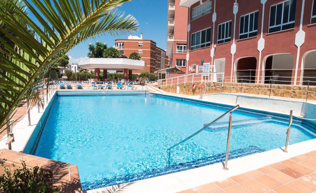 uma grande piscina azul ao lado de um edifício em Seramar Hotel Luna Park Adults Only em El Arenal