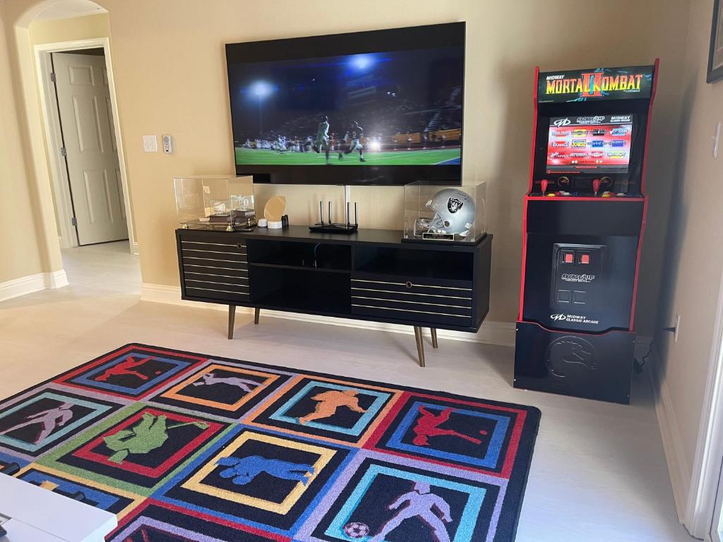 a living room with a television and a rug at Sports Themed 2bedApt w BEST location fully stocked 2 parking in Santa Clara