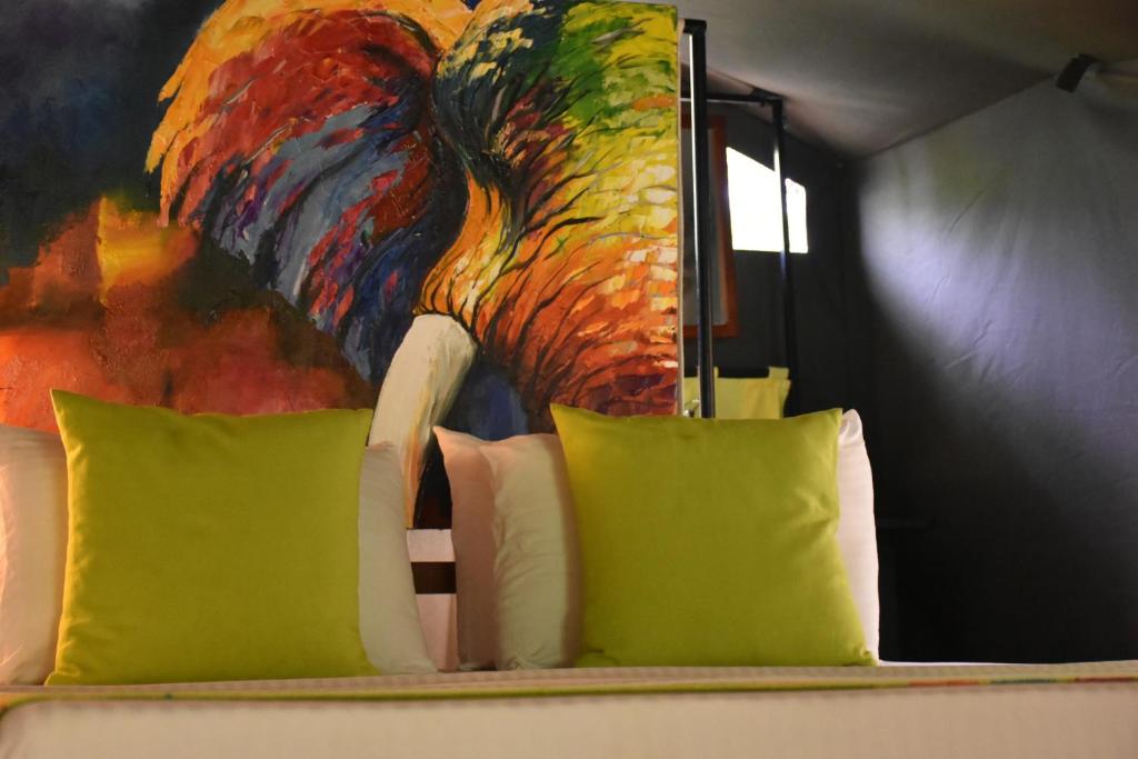 a bed with two pillows and a painting of a bird at Mahoora Wilpattu - by Eco Team in Wilpattu