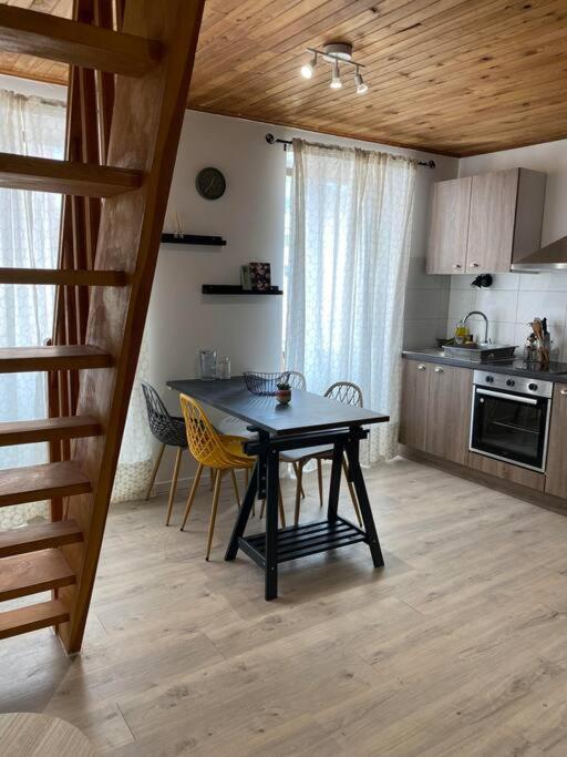 une cuisine avec une table et des chaises dans une pièce dans l'établissement L'appart de la liberté, à Millau