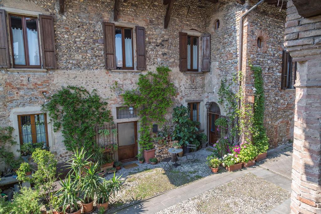 ein altes Steingebäude mit Pflanzen und Fenstern in der Unterkunft La Locanda della Torre in Marne di Filago
