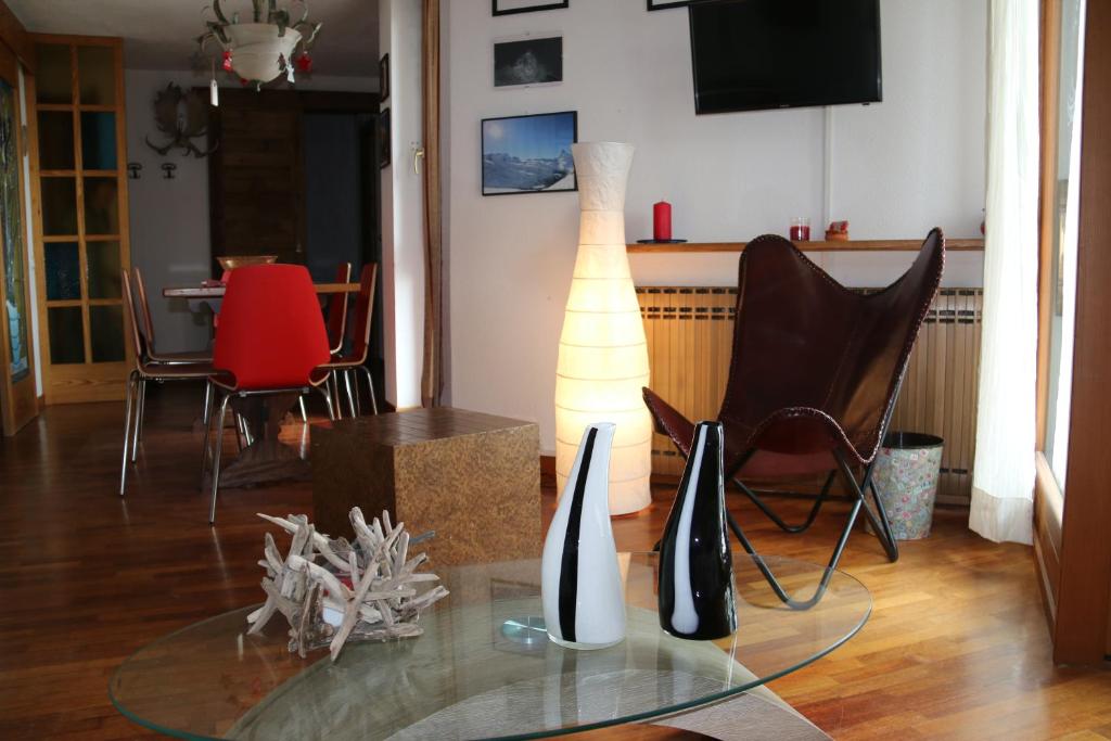 salon ze szklanym stołem, lampką i krzesłami w obiekcie Giomein appartamento sulle piste , CIR 0280 w mieście Breuil-Cervinia