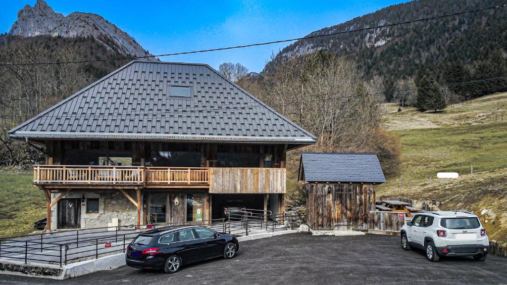 two cars parked in a parking lot in front of a building at La grange au ruisseau in Bellecombe-en-Beauges