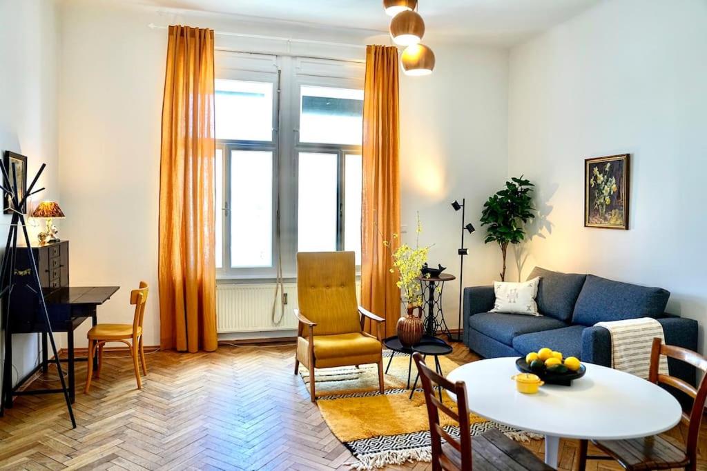 sala de estar con sofá azul y mesa en Stilvolles Apartment im Zentrum en Graz