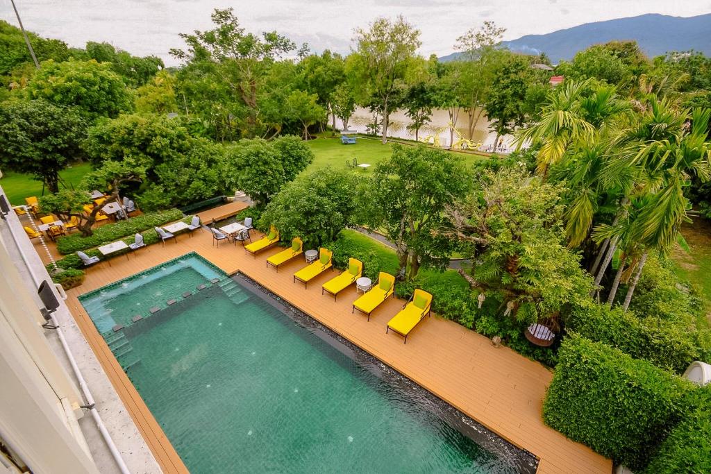 An elevated view shows a rectangular pool, sun loungers, gardens, and mountains beyond.