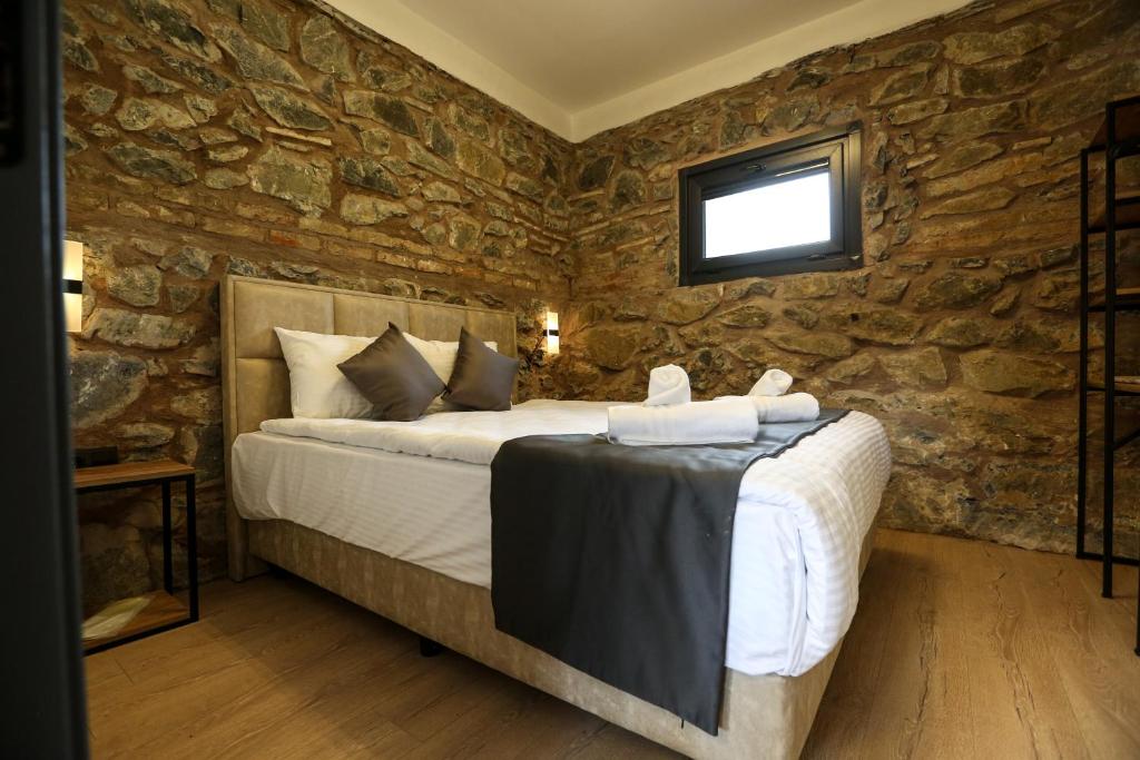 a bedroom with a bed in a stone wall at Mia Mia Suites in Istanbul
