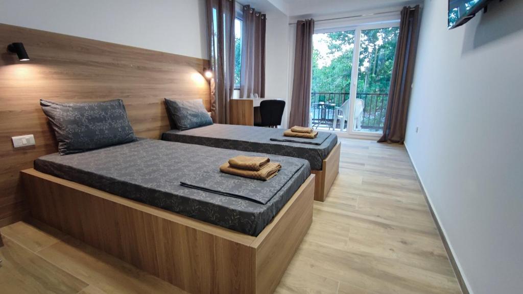 a bedroom with two beds and a large window at Villa Natali in Ohrid